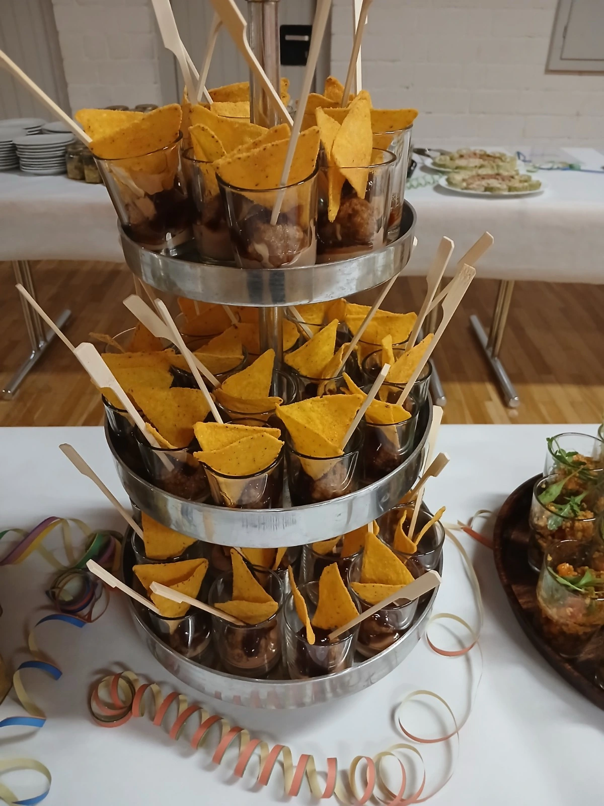 Franken Food Express – Catering-Service für Partys – Dieser dreistöckige Catering-Ständer bietet einzelne Gläser mit Dips und Tortilla-Chips.